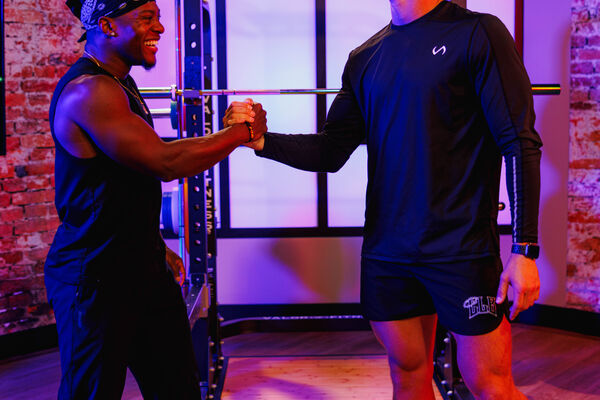 Two fitness creators connecting with a handshake